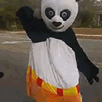 a person dressed in a panda costume is standing on a street .