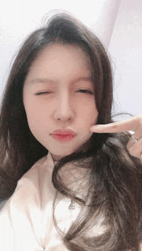 a woman making a funny face with her finger on her face