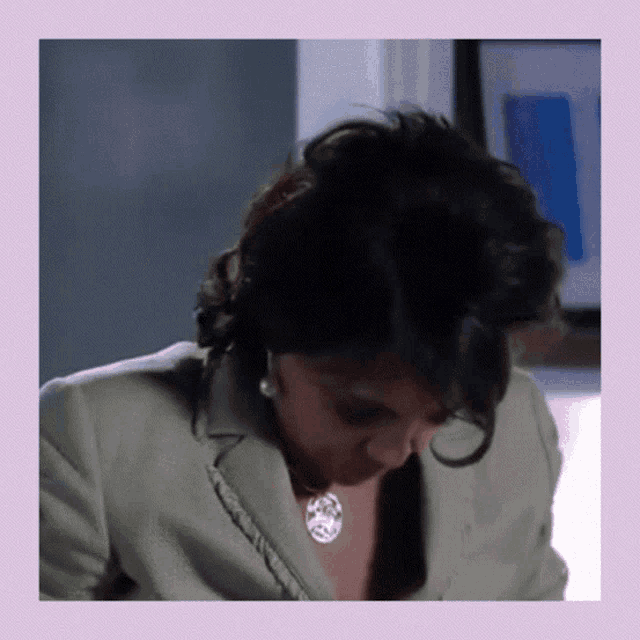 a woman wearing a necklace and pearls is looking down