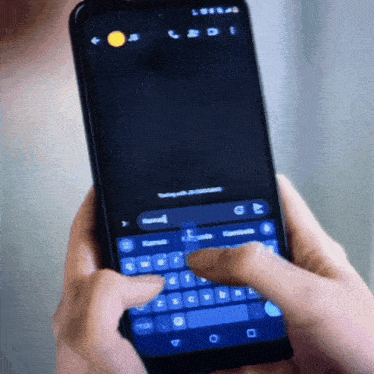 a person is typing on a cell phone with a yellow circle on the top left