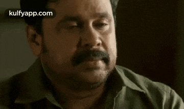 a man with a beard and mustache is looking at the camera .