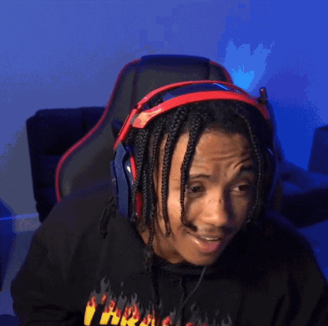 a man wearing headphones and a shirt that says thrasher on it