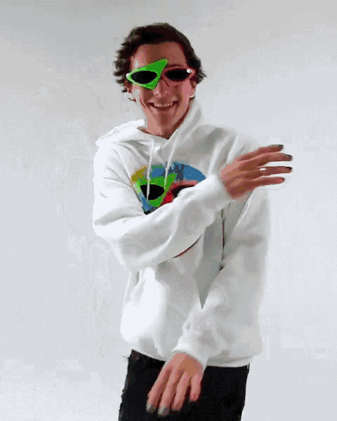 a man wearing a white hoodie with a rainbow smiley face on it