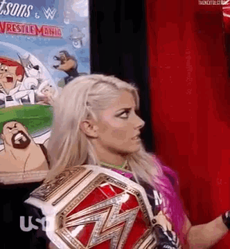 a woman is holding a wrestling championship belt in front of a screen .