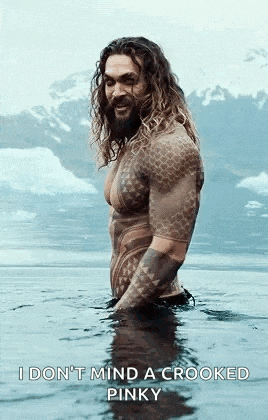 a man with tattoos is standing in the water .