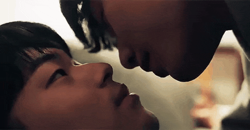 a close up of two men kissing each other on the forehead .