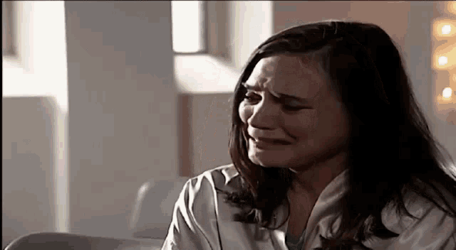 a woman is crying and making a funny face while sitting in a chair .