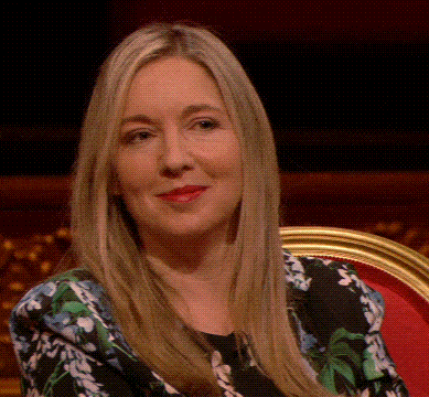 a woman with long blonde hair is sitting in a chair