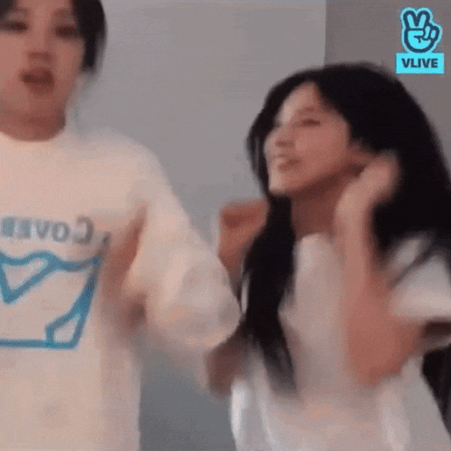 a couple of women are standing next to each other and dancing in a room .
