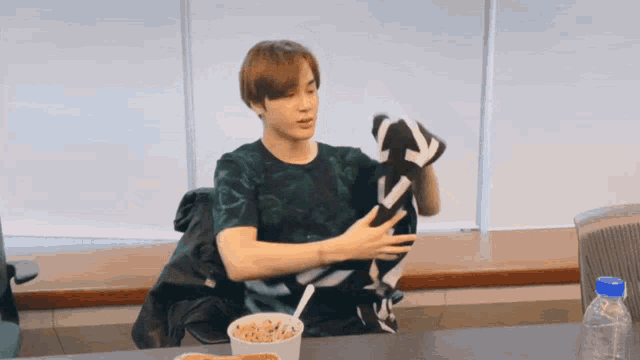 a young man is holding a blanket that has the letter s on it