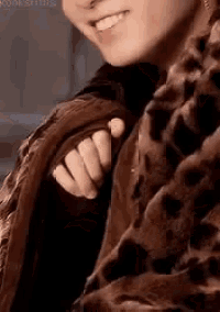 a close up of a person wearing a fur coat and a scarf .