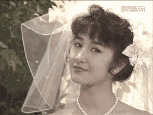 a woman in a wedding dress with a veil and pearls is on a pps tv channel
