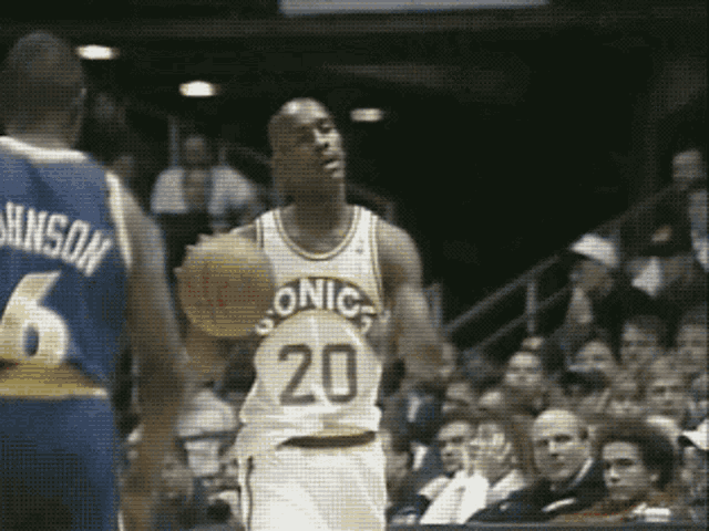 a basketball player with the number 20 on his jersey is dribbling the ball