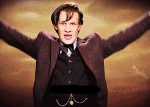 a man in a suit and tie is standing with his arms outstretched and a black x on his stomach