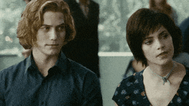 a man and a woman are standing next to each other in a room