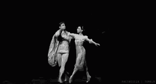 a man and a woman are dancing in a black and white photo .