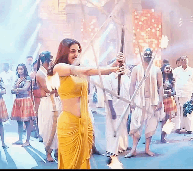 a woman in a yellow dress is holding a bow and arrow in front of a crowd