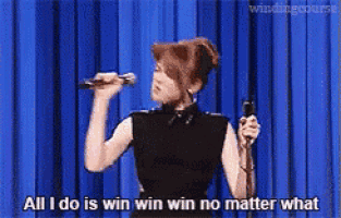 a woman singing into a microphone with the words all i do is win win win no matter what