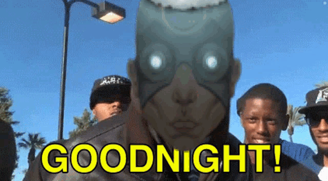 a group of people are standing in front of a man with a mask on his face and the words goodnight written in yellow letters .