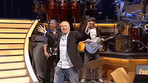 a man in a suit and jeans is dancing on a stage
