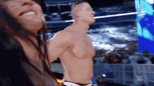 a man and a woman are standing in a wrestling ring .