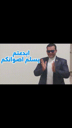 a man wearing sunglasses and a suit is clapping his hands in arabic