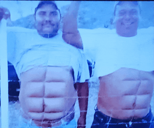 two men are posing for a picture with their arms up