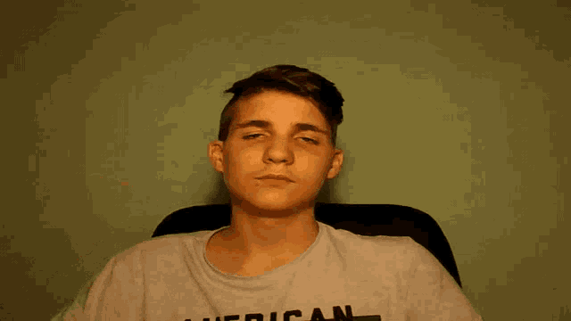 a young man wearing a grey american t-shirt