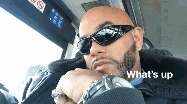 a man wearing sunglasses and a watch with the words what 's up written below him