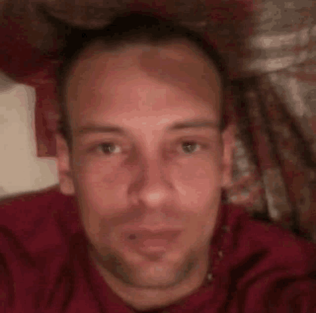 a man is laying on a bed and taking a selfie .