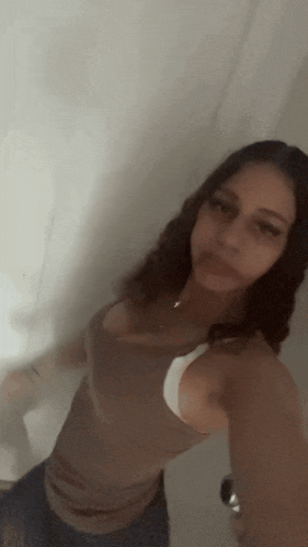 a woman taking a selfie in front of a wall