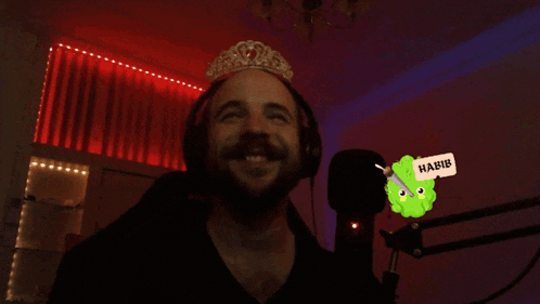 a man wearing headphones and a tiara with a sticker that says habib on it