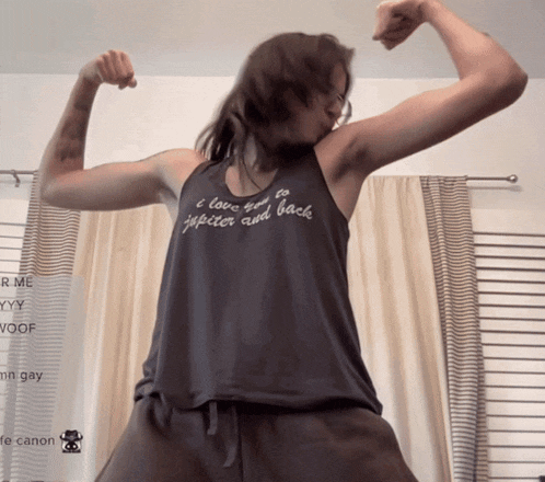 a woman flexes her muscles wearing a tank top that says " i love you to jupiter and back "