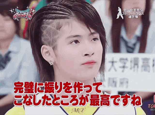 a girl with a braided hair style is sitting in front of a sign that says mq