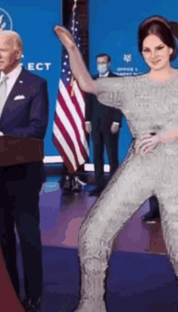 a man in a suit and tie is standing next to a woman in a jumpsuit
