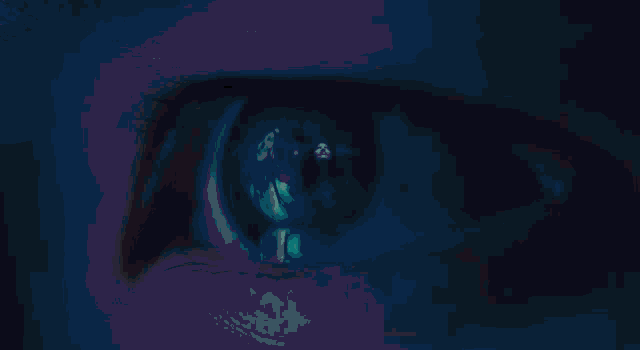 a close up of a person 's blue eye with a blue background