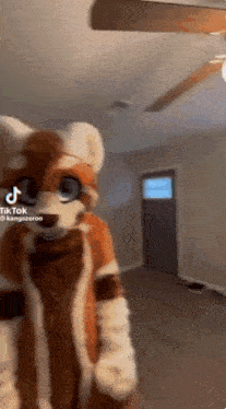 a person in a furry costume is standing in a living room .
