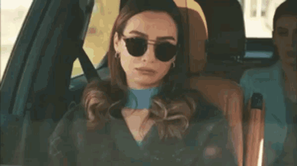 a group of people are sitting in a car with a man driving it .