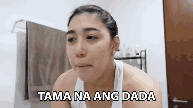 a woman in a white tank top with the words tama na ang dada on her face