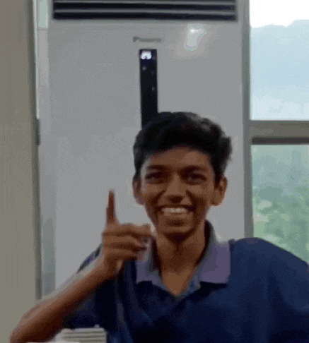 a young man is smiling and giving a thumbs up in front of an air conditioner