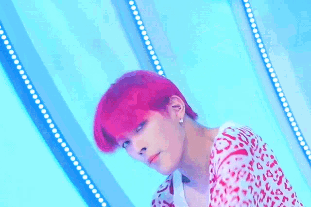 a young man with red hair is holding a white microphone in his hand .