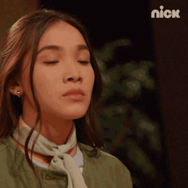 a close up of a woman 's face with a nick logo in the background