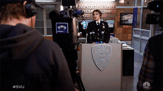 a police officer stands at a podium in front of a camera