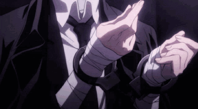 a man in a suit and tie with bandaged wrists