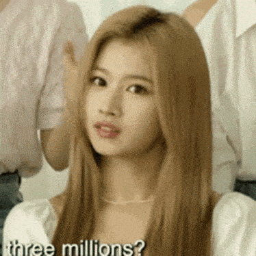 a woman with long blonde hair is standing in front of a group of people .