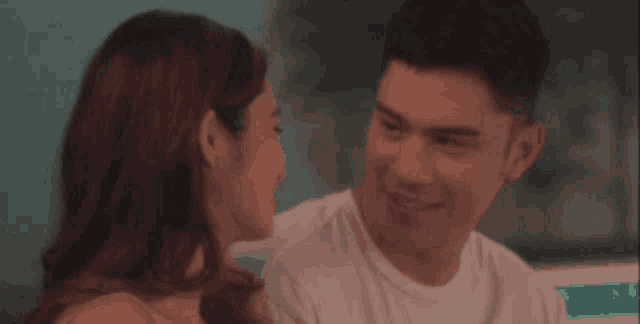 a man and a woman are looking at each other .