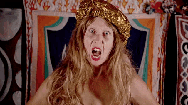 a woman with blonde hair and a gold hat is making a face