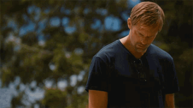 a man wearing sunglasses and a black shirt is looking down