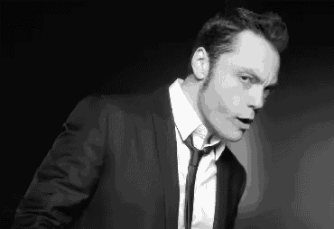 a man in a suit and tie looks at the camera