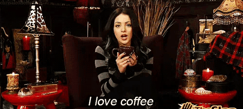 a woman sits in a chair holding a cup of coffee and says i love coffee